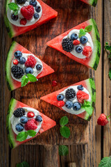 Sweet watermelon pizza with whipped cream and fresh berry fruits.