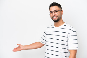 Fototapeta premium Young Arab handsome man isolated on white background extending hands to the side for inviting to come