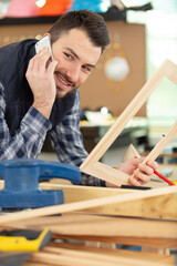 man using smart phonein carpentry