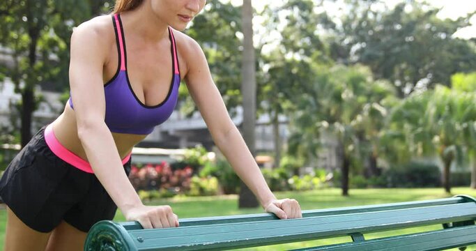 Woman doing push-ups exercise in the park during her fitness workout
