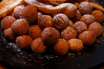 Onbaked castagnole and Frappe or chiacchiere typical Italian carnival fritters dusted with powdered sugar. Biscuits with sugar for the carnival of Venice. Traditional sweet pastries