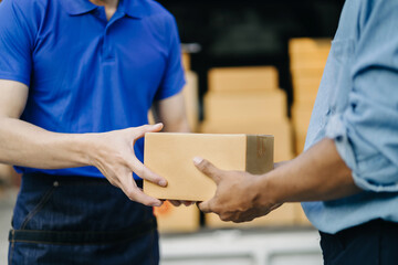 Male hand accepting delivery of box from delivery man in the morning.