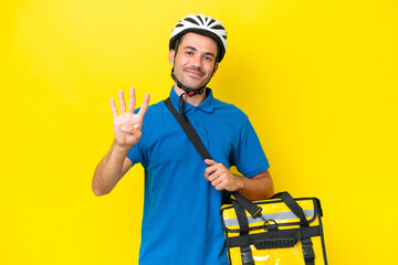 Young handsome man with thermal backpack over isolated yellow background happy and counting four with fingers