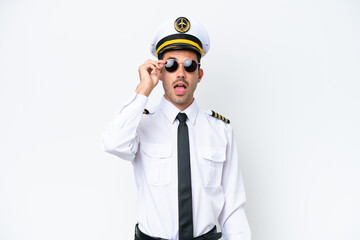 Airplane pilot over isolated white background with glasses and surprised