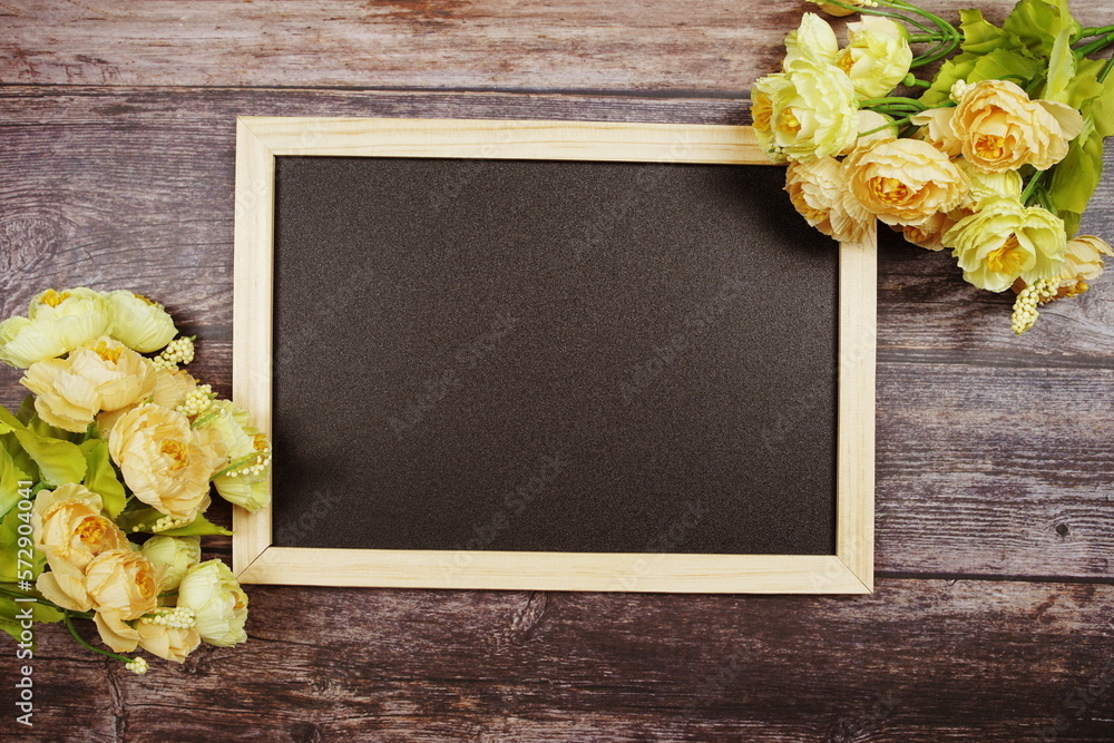 Canvas Prints Empty Blackboard with flowers decoration on wooden background