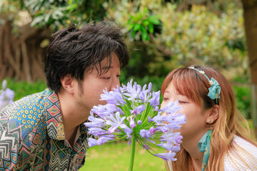 Fototapeta premium 紫色の花に隠れてキスするカップル