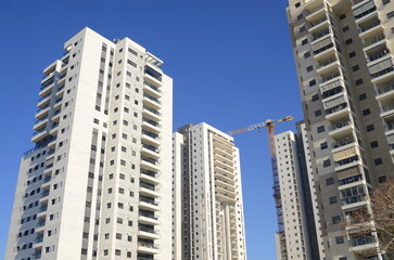 Fototapeta na wymiar Beautiful white residential buildings. Modern area, new buildings. Real estate in Israel. Tenement house Tall new residential buildings against the sky, space for text