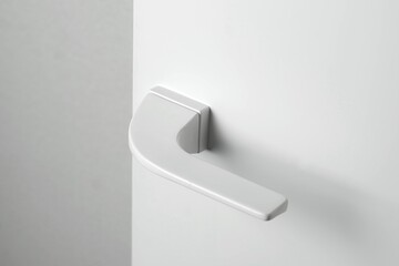 White door, with beautiful white handles, on a white background, with a place for an inscription