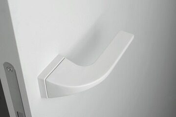 White door, with beautiful white handles, on a white background, with a place for an inscription