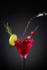 Cranberry cocktail garnished with berries, lime, and rosemary.