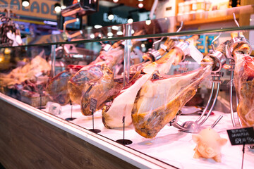 Food store with jamon in La Boqueria market one of the most popular tourist landmark in the Ciudad Vieja district. Barcelona market, ​​Spain