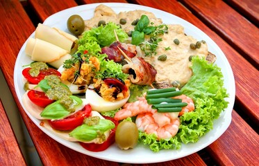 Teller mit Vitello Tonnato und Carpaccio und leckeren Häppchen auf einem Tisch