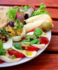 Teller mit Vitello Tonnato und Carpaccio und leckeren Häppchen auf einem Tisch