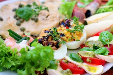 Teller mit Vitello Tonnato und Carpaccio und leckeren Häppchen auf einem Tisch