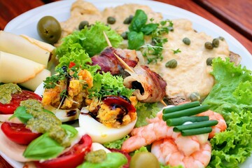 Teller mit Vitello Tonnato und Carpaccio und leckeren Häppchen auf einem Tisch