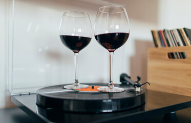 Glasses of red wine swirling on the spinning vinyl record