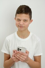 Wow excited young Asian man showing mobile phone with open hand gesture isolated on yellow background. High quality photo