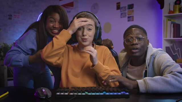 Excited diverse group of friends playing video game online together, having fun gaming pc esport