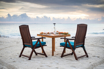 romantic dinner table setting on sunset beach