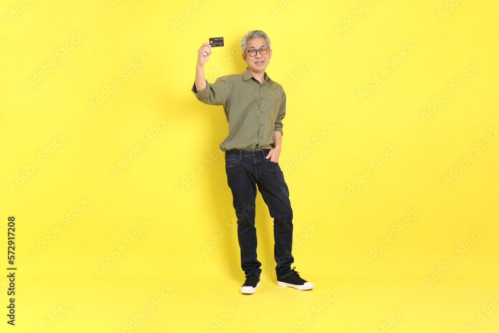 Sticker The 40s adult Asian man with casual dressed standing on the yellow background.