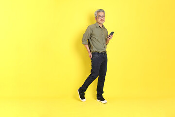 Fototapeta na wymiar The 40s adult Asian man with casual dressed standing on the yellow background.