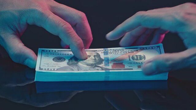 Close up hands giving money - United States Dollars (or USD) bribe payment. offering batch of hundred dollar bills bribery financial economy business people. Venality, bribe, corruption concept.