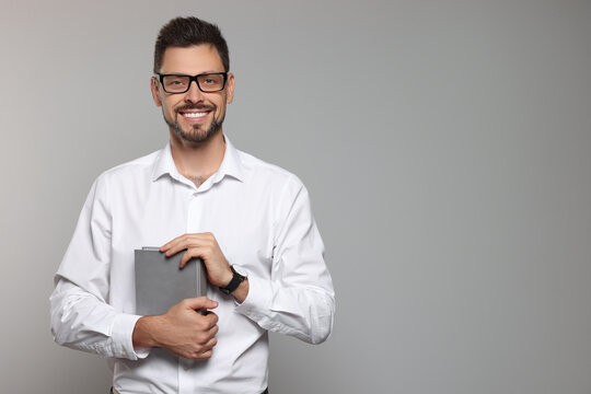 Happy teacher with glasses and book against beige background. Space for text