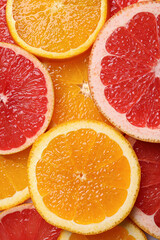 Slices of grapefruit and orange as background, top view
