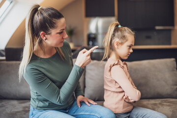 Angry mother is scolding at her daughter.