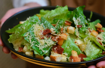 Caesar salad served with organic lettuce, crispy bread and sprinkled with cheese is a meal for health lovers.