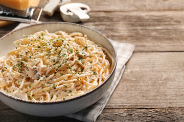 Delicious pasta with mushroom sauce on wooden table. Space for text
