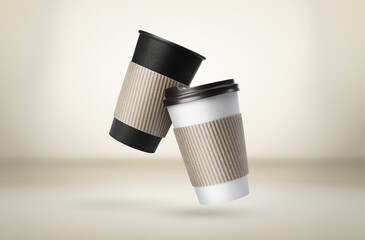 Takeaway paper cups falling on beige background