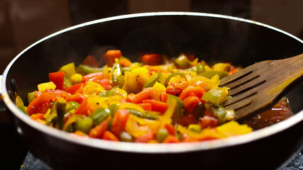Close-up view of mix of colored vegetables cooking over pan. steaming mixed vegetables in the wok, asian style cooking vegetarian and healthy