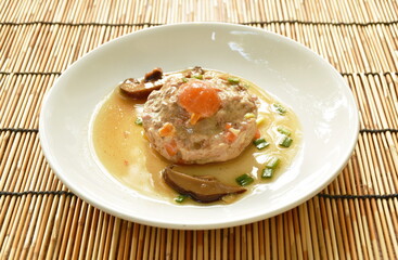 steamed chop pork topping salty egg yolk with mushroom in gravy sauce on plate