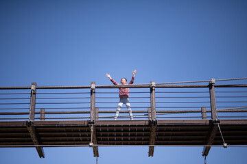 吊り橋から手を振る子供