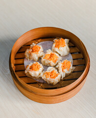Chicken steamed dumpling dim sum in traditional bamboo steamer on white background