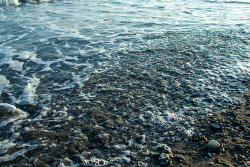 The mediterranean sea washing over a stony beach