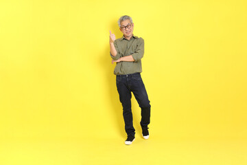 Fototapeta premium The 40s adult Asian man with casual dressed standing on the yellow background.