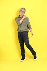 Fototapeta premium The 40s adult Asian man with casual dressed standing on the yellow background.