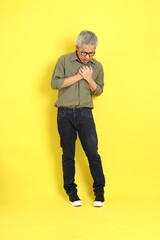 Fototapeta premium The 40s adult Asian man with casual dressed standing on the yellow background.