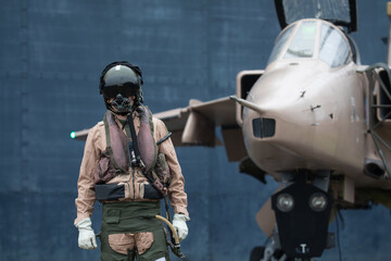 Fighter pilot standing with fighter Jet ready for a combat mission wearing flying helmet, suit and dark visor with oxygen mask © Chris Chambers
