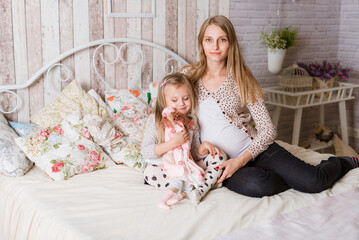 Happy daughter hugging her future mother's belly at home. the girl listens to the movements of the...