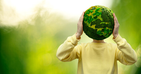 Woman holds a green planet Earth in place of the head. Symbol of sustainable development and renewable energy	