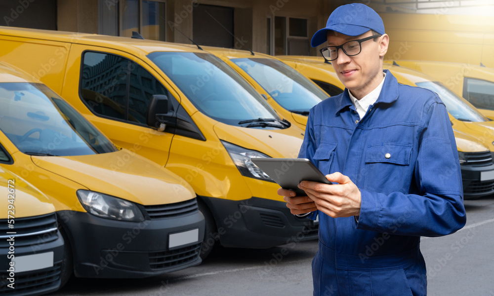 Poster Manager with a digital tablet on the background of vans. Fleet management