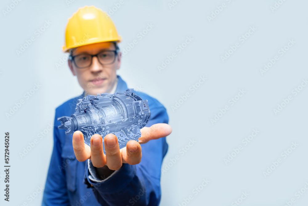 Poster development engineer holds in his hands a model of an electric motor created in augmented reality.