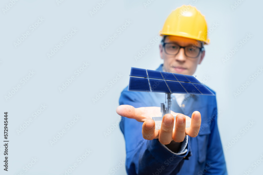 Poster development engineer holds in his hand a model of a solar panel created in augmented reality.