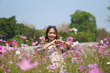 Happy Asian woman in cosmos flower garden