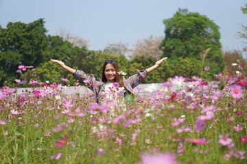 Obraz na płótnie Canvas Happy Asian woman in cosmos flower garden