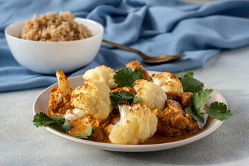 Cauliflower curry with coconut yogurt and cilantro leaves. Brown rice for serving. Vegetarian food concept