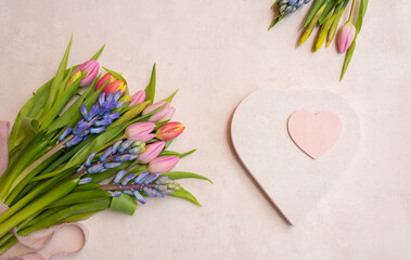 Arrangement with colorful spring flowers, heart shape on soft pink pastel background. Top view,...